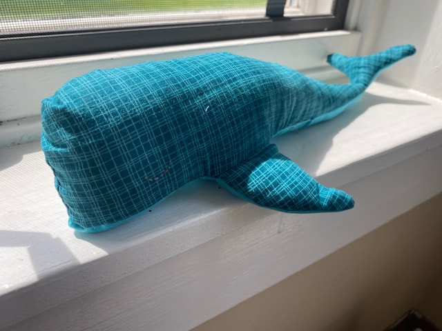 blue whale stuffed animal on a windowsill